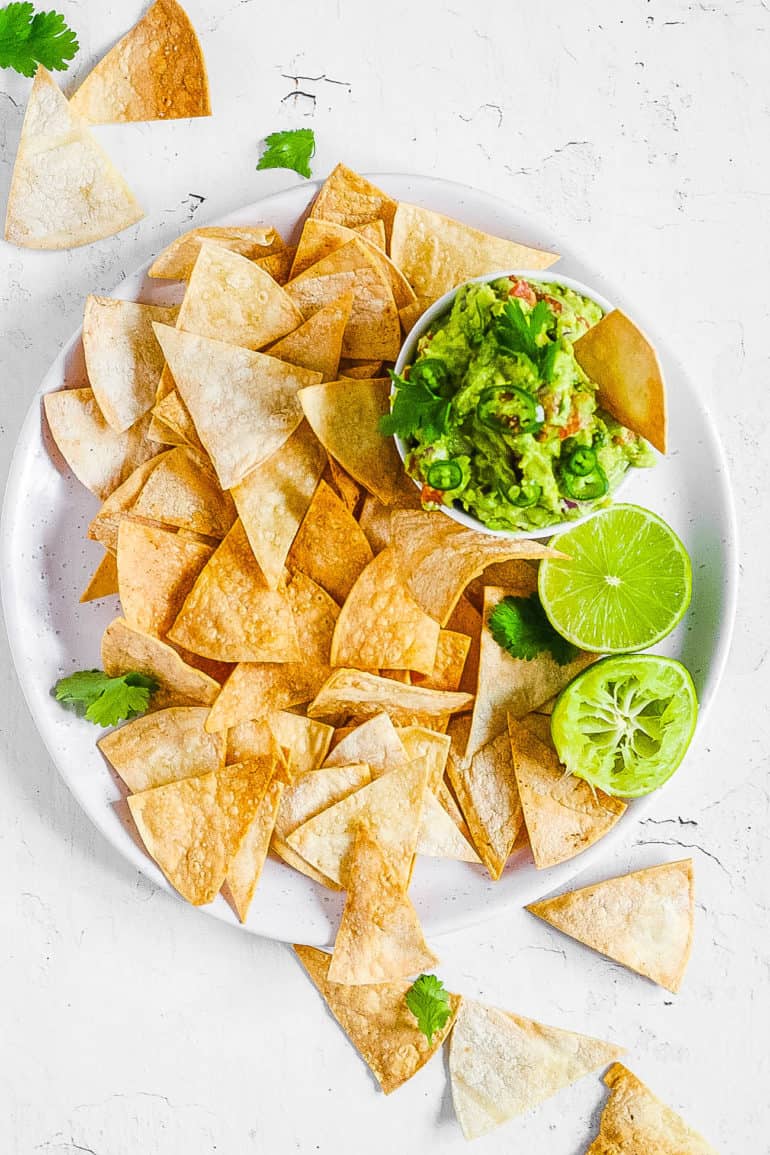 air fryer tortilla chips served with guacamole on a white plate
