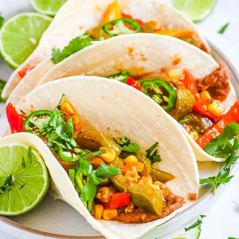 black bean fajitas topped with fresh cilantro and lime on a white plate