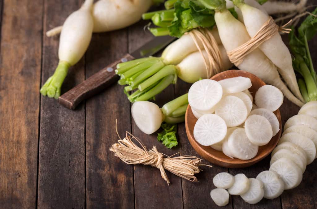 White organic radishes on the wooden table