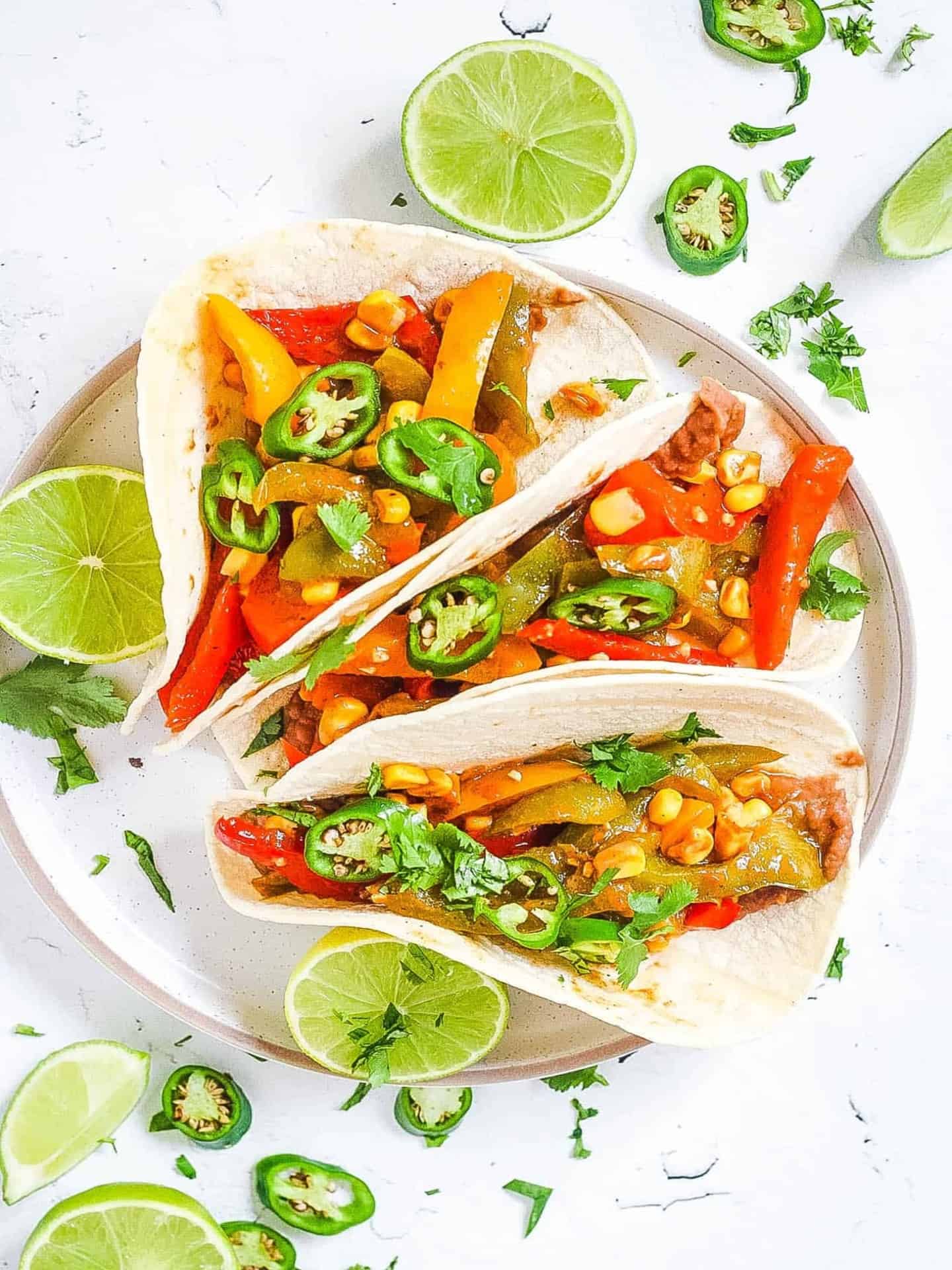 easy black bean fajitas on white plate with limes and jalapeños