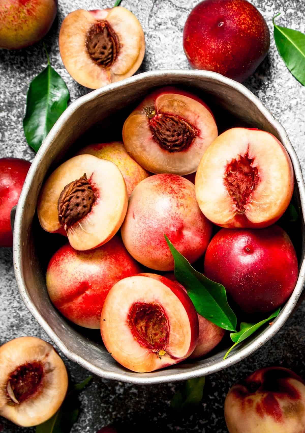 Nectarines cut in half in bowl (foods that start with n)