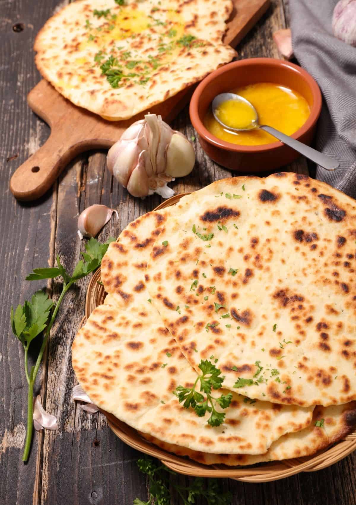 Naan bread stacked on flat basket.