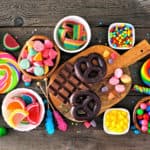 Colorful sweet low calorie candy buffet table scene. Above view over a rustic wood background.