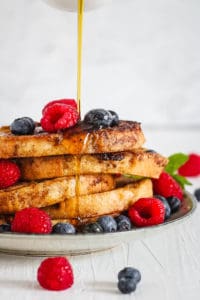 quick healthy french toast with berries and syrup served on a white plate