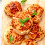 air fryer pizza rolls topped with basil on a cutting board