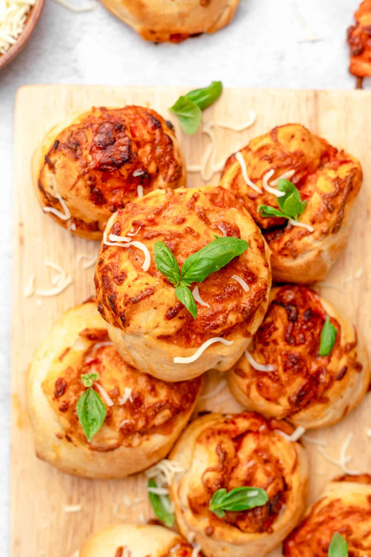 air fryer pizza rolls topped with basil on a cutting board