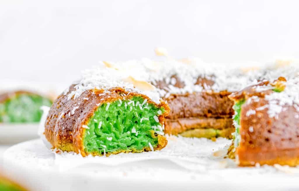 Vietnamese honeycomb Cake cut to show green pandan inside, served on a white plate