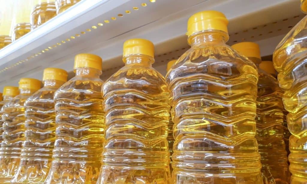 Vegetable oil containers on grocer store shelf. - best oil to season cast iron