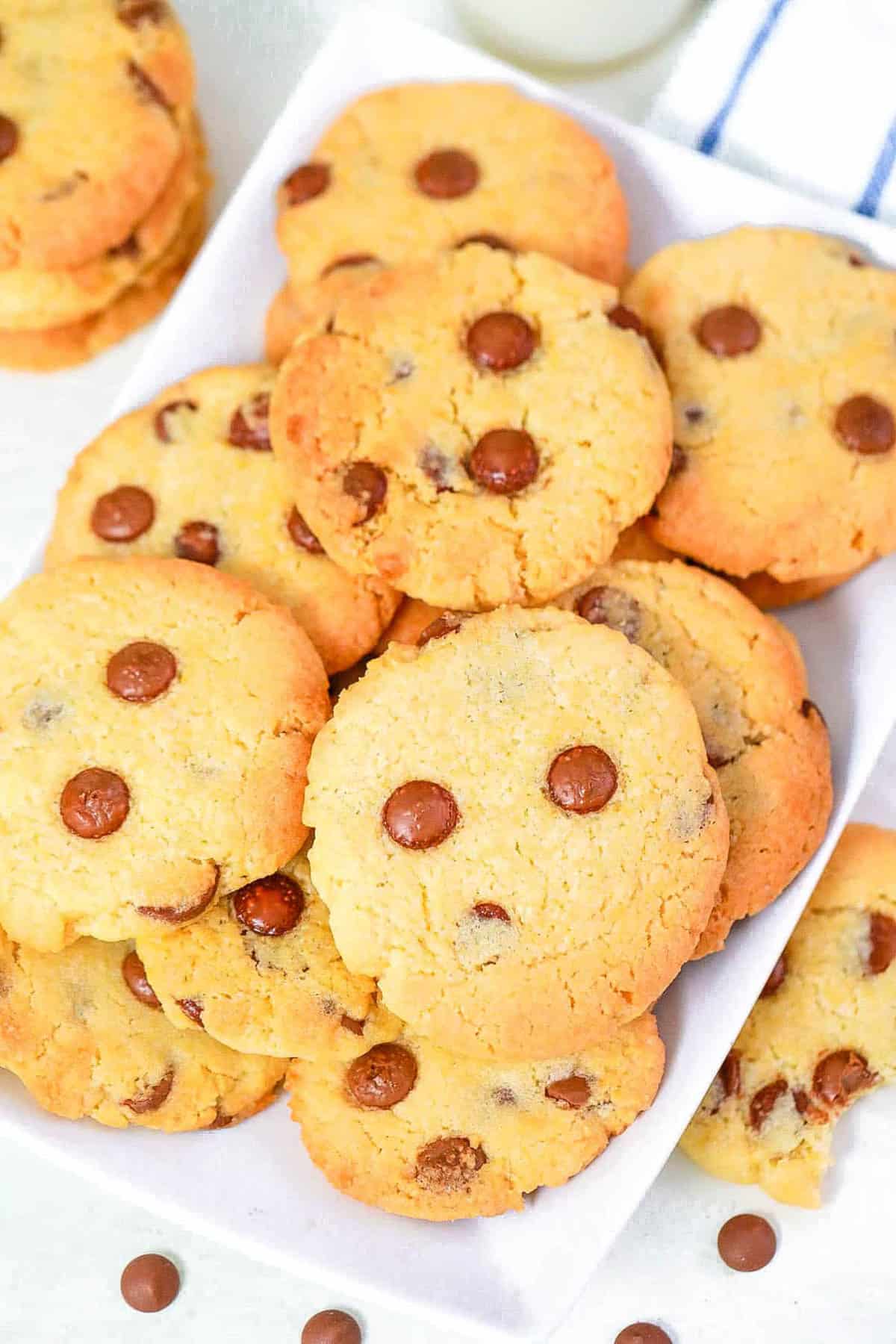 Chocolate chip cookies without brown sugar stacked on a white serving platter.