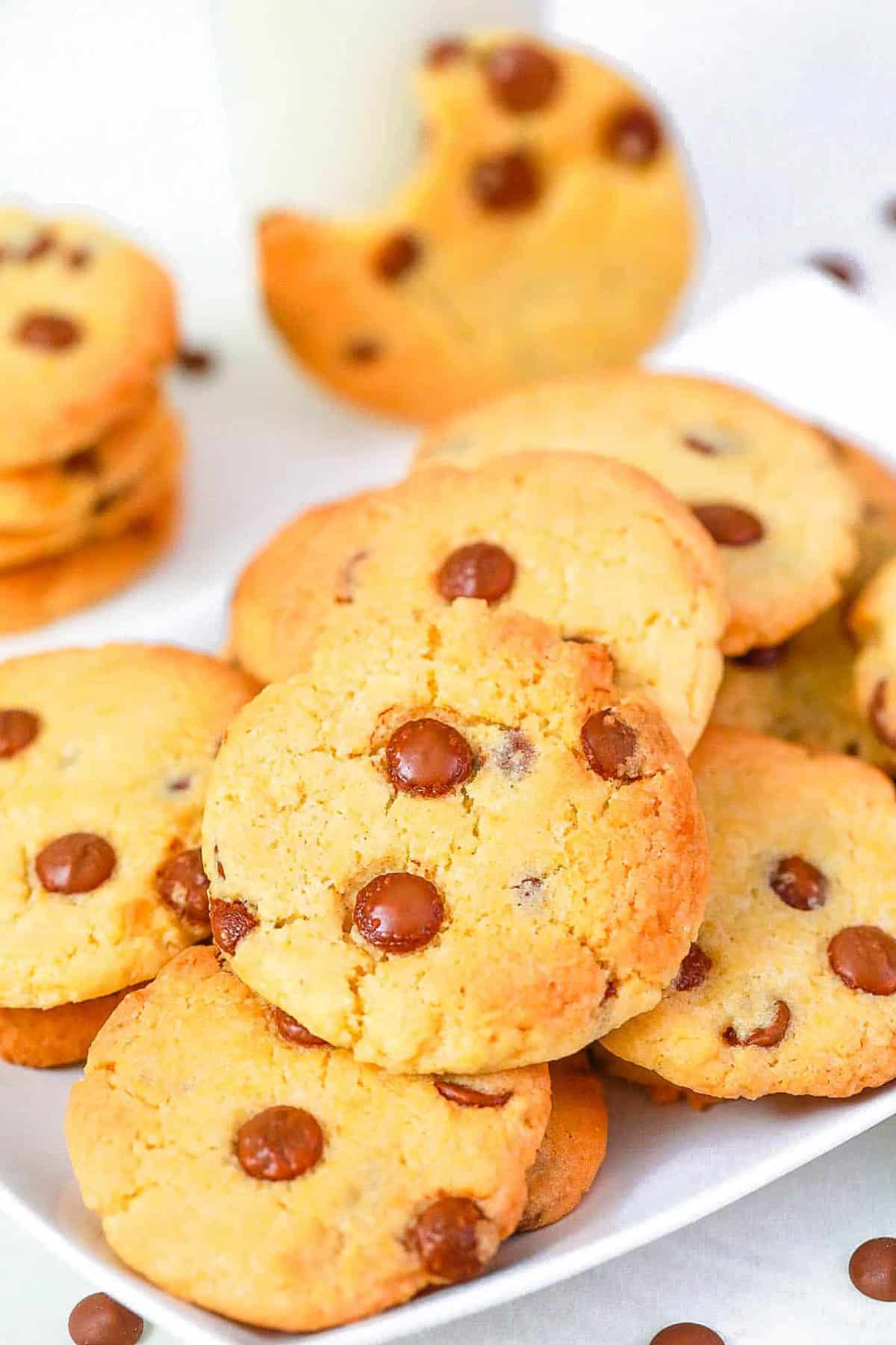 Chocolate chip cookies without brown sugar stacked on a white serving platter.