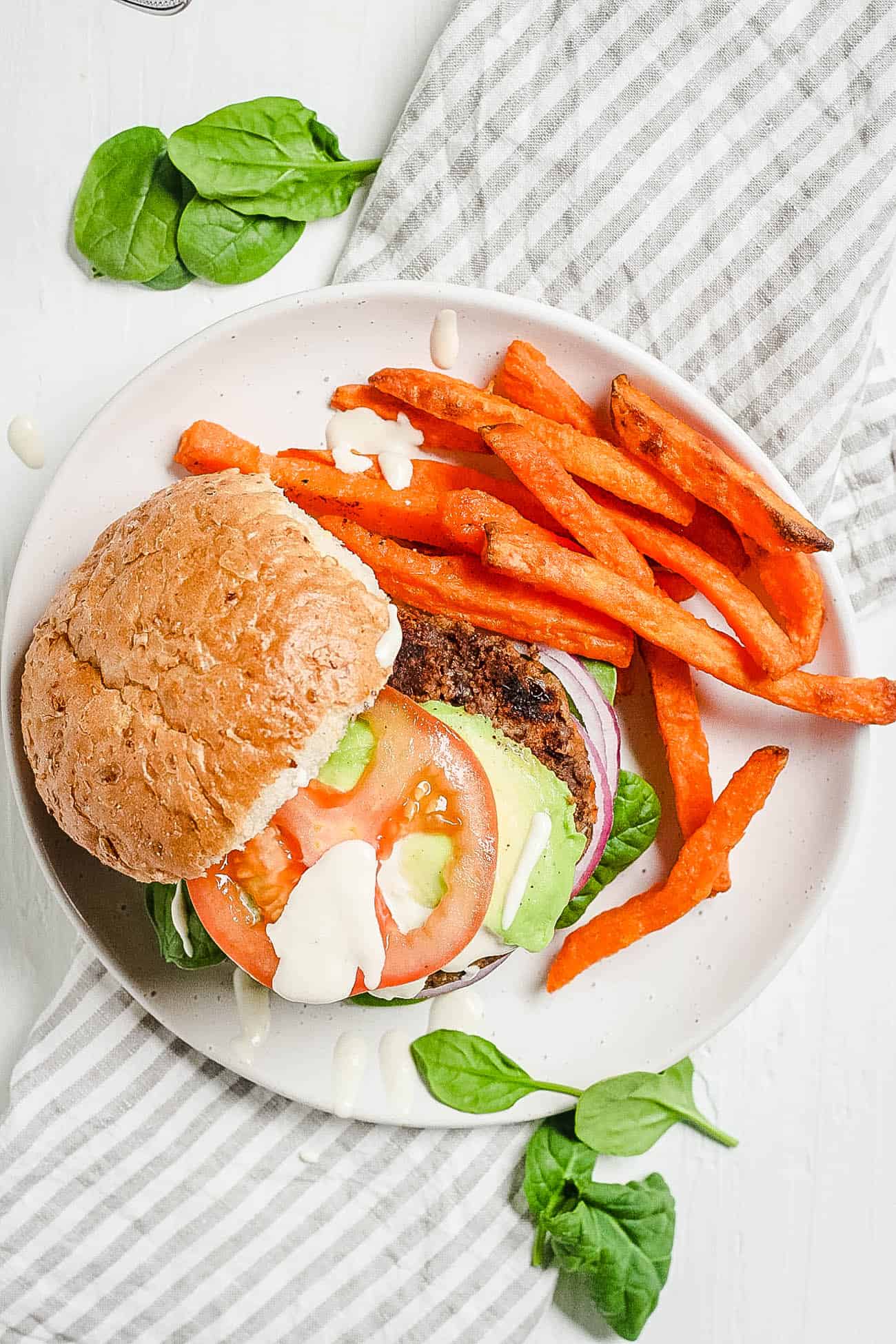 chipotle black bean burgers with tahini sauce and sweet potato fries top view