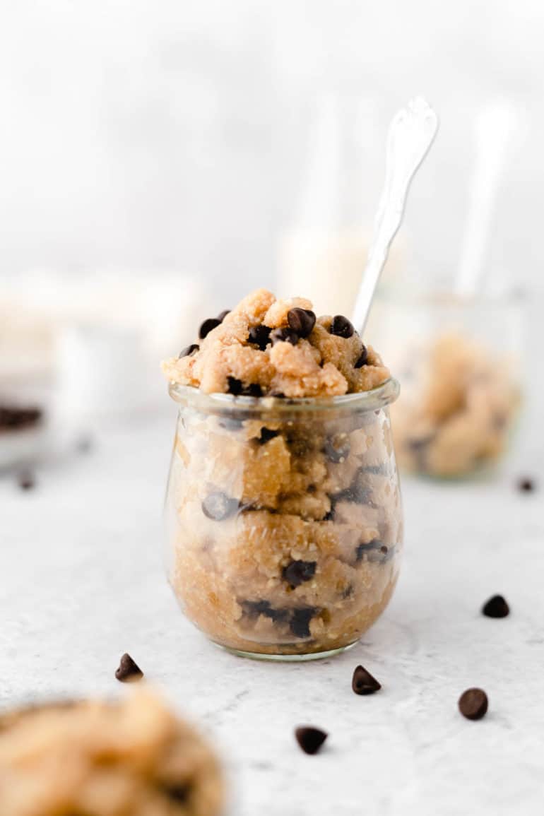 healthy vegan edible cookie dough in a glass jar with a spoon