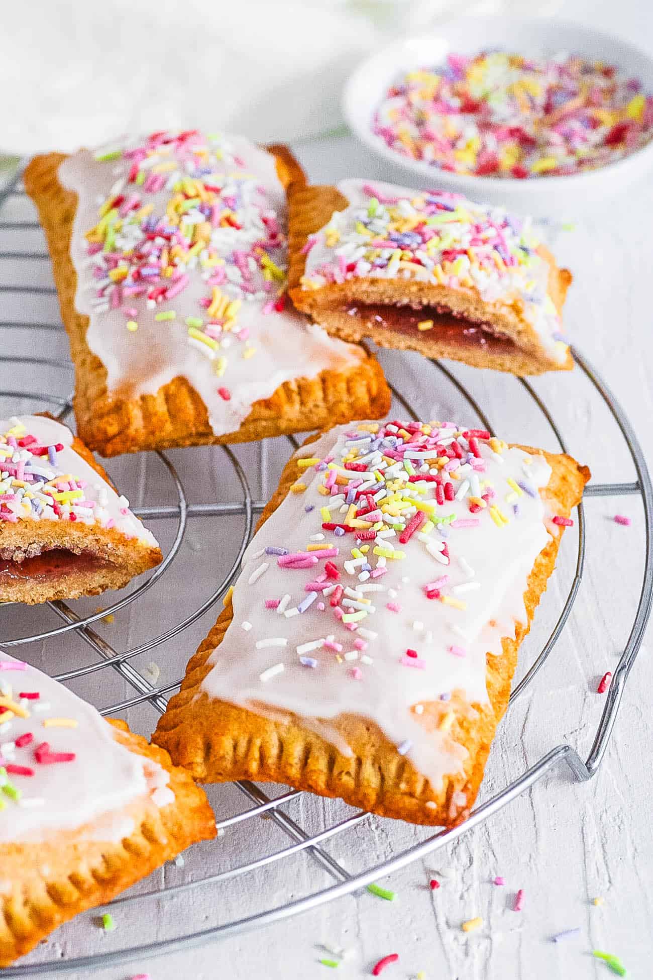 healthy homemade vegan pop tarts with strawberry filling with rainbow sprinkles and coconut yogurt icing