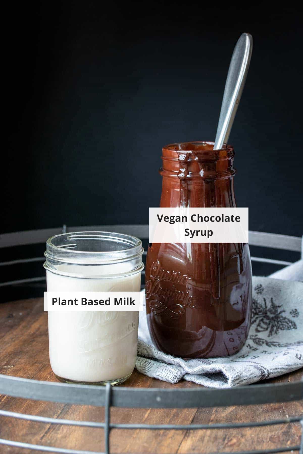 Ingredients for vegan homemade chocolate milk on a wood background.