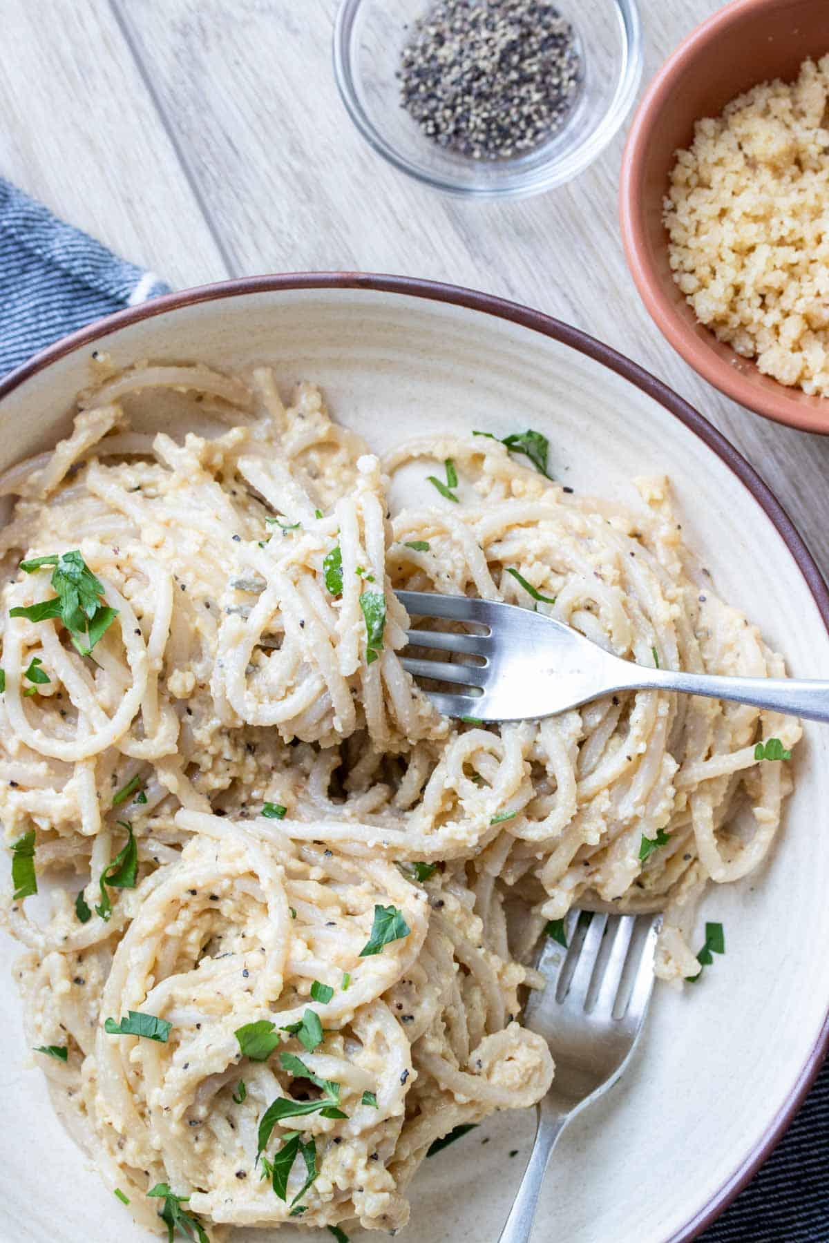 Vegan cacio e pepe served on a white plate.