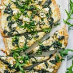 vegetarian florentine pizza - white pizza with spinach and parmesan cheese on a white platter