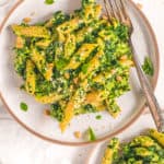 vegetarian pesto pasta recipe with spinach, basil and pine nuts on a white plate