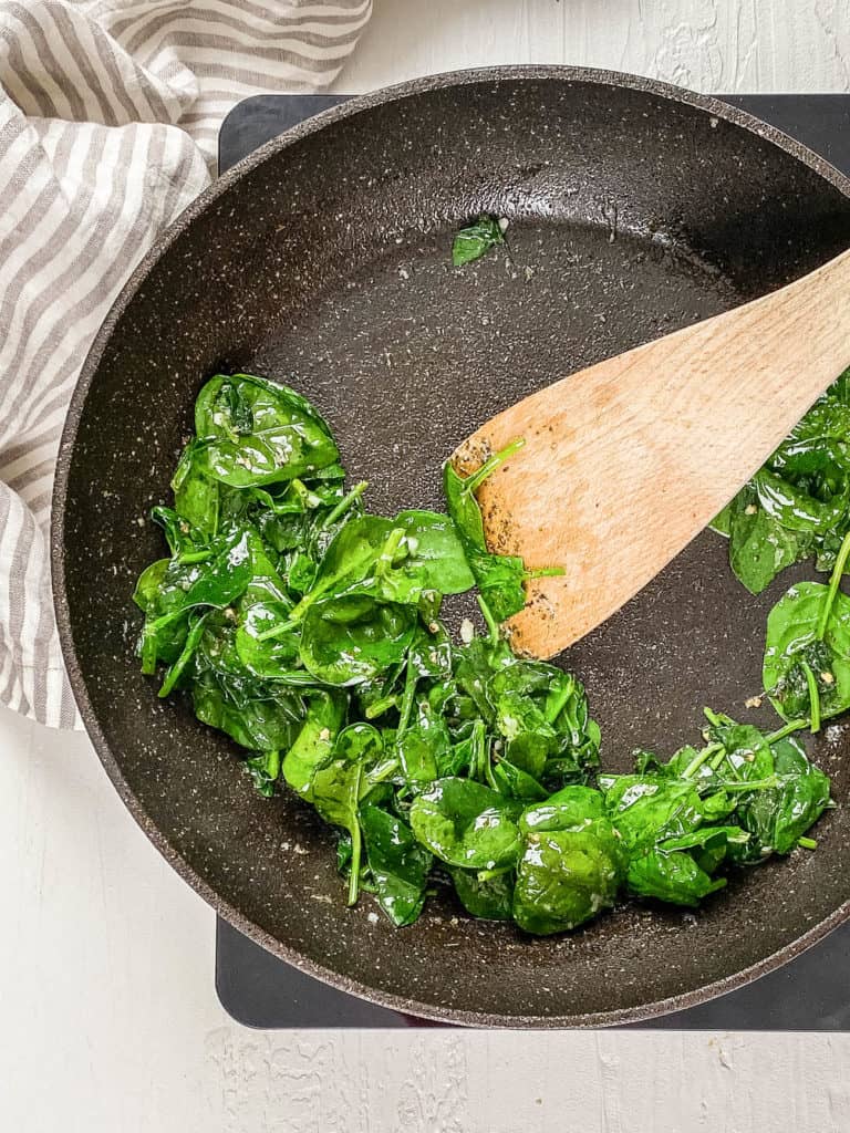 Baby spinach wilted in a pan.