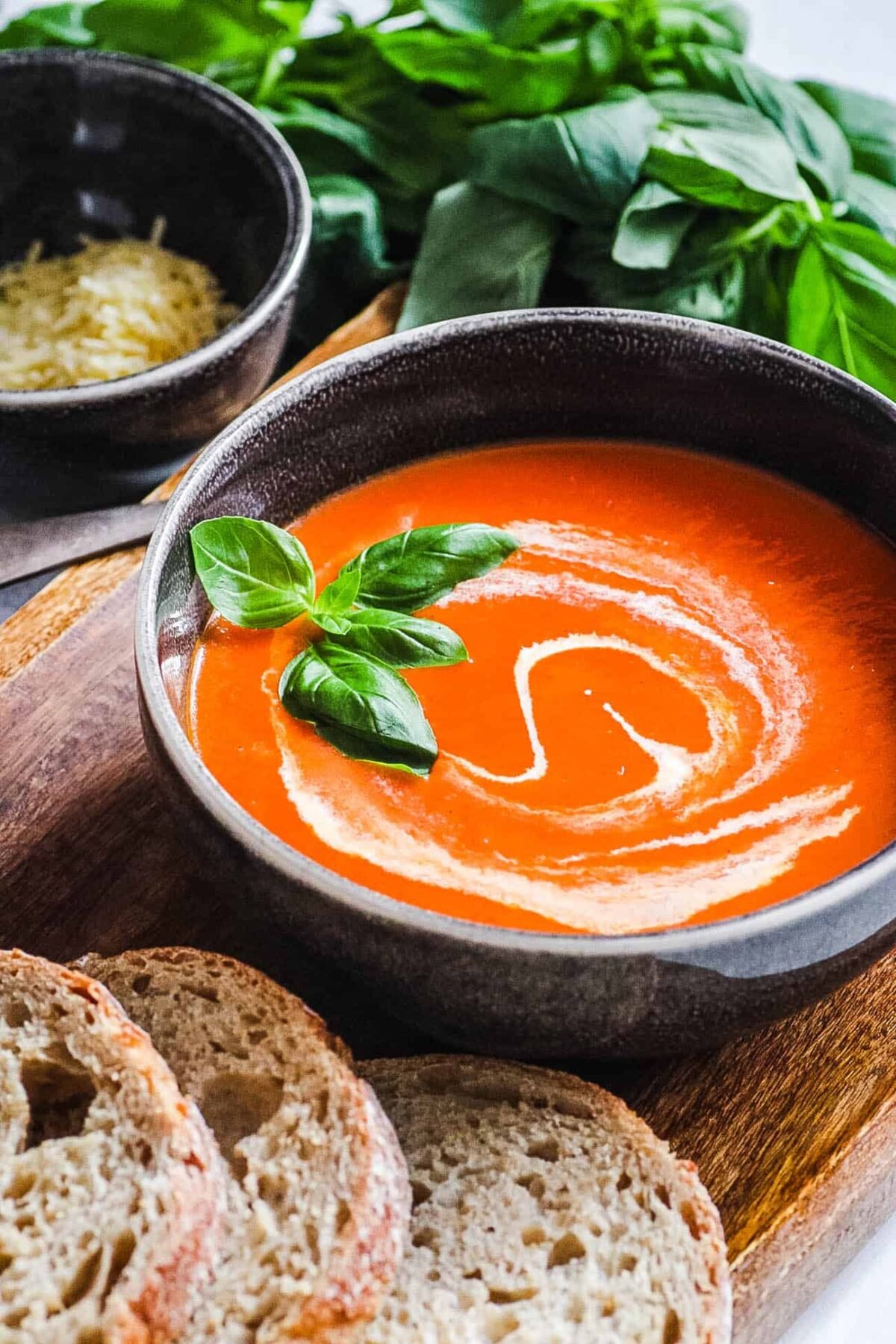 easy instant pot tomato soup (keto tomato soup) with basil and cream served in a black bowl