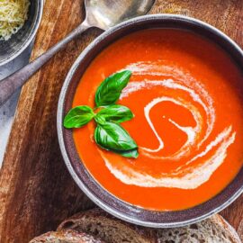 easy instant pot tomato soup (keto tomato soup) with basil and cream served in a black bowl