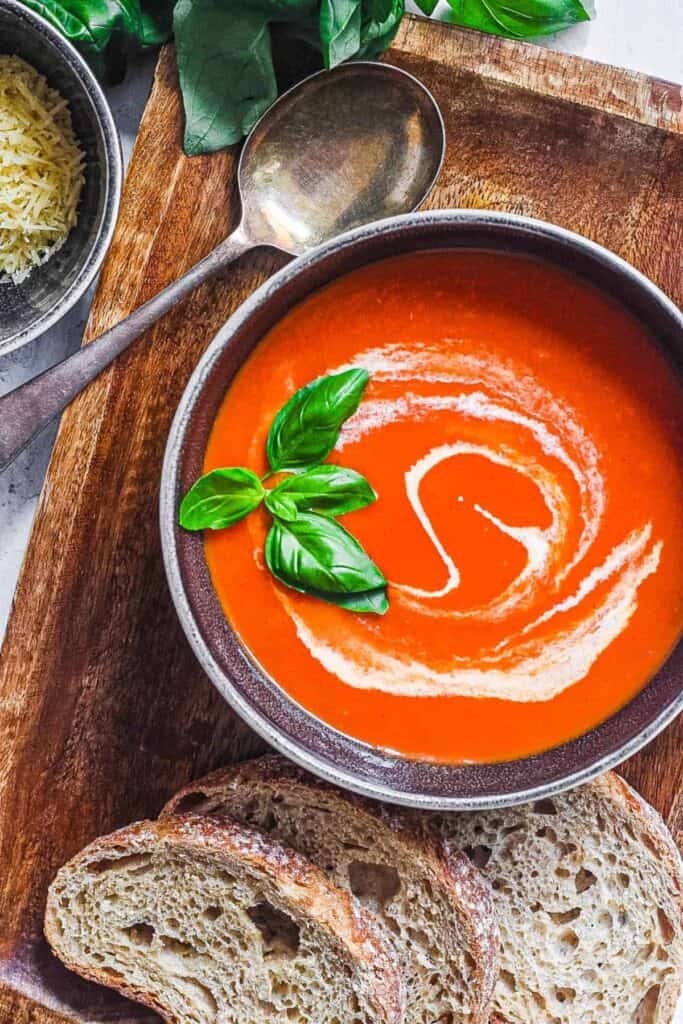 easy instant pot tomato soup (keto tomato soup) with basil and cream served in a black bowl