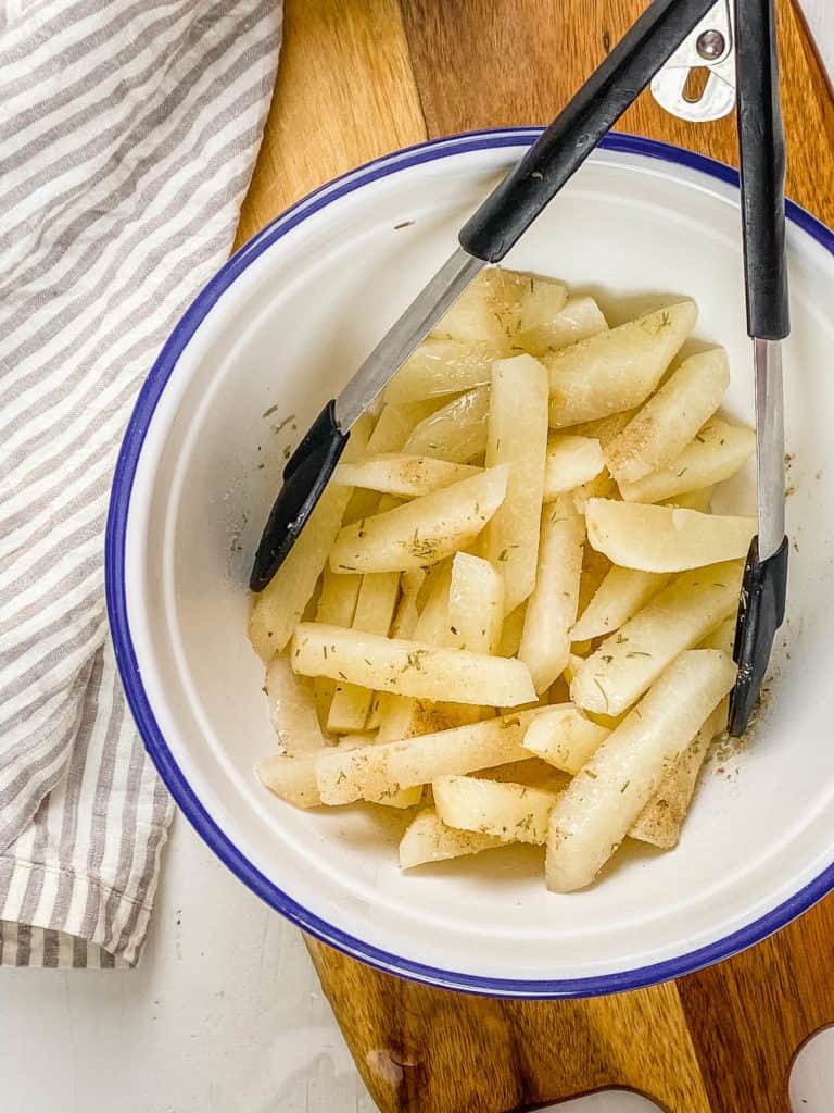 jicama slices picked up with tongs
