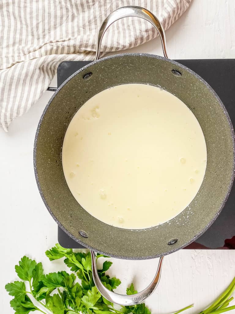 homemade alfredo sauce cooking in a pot