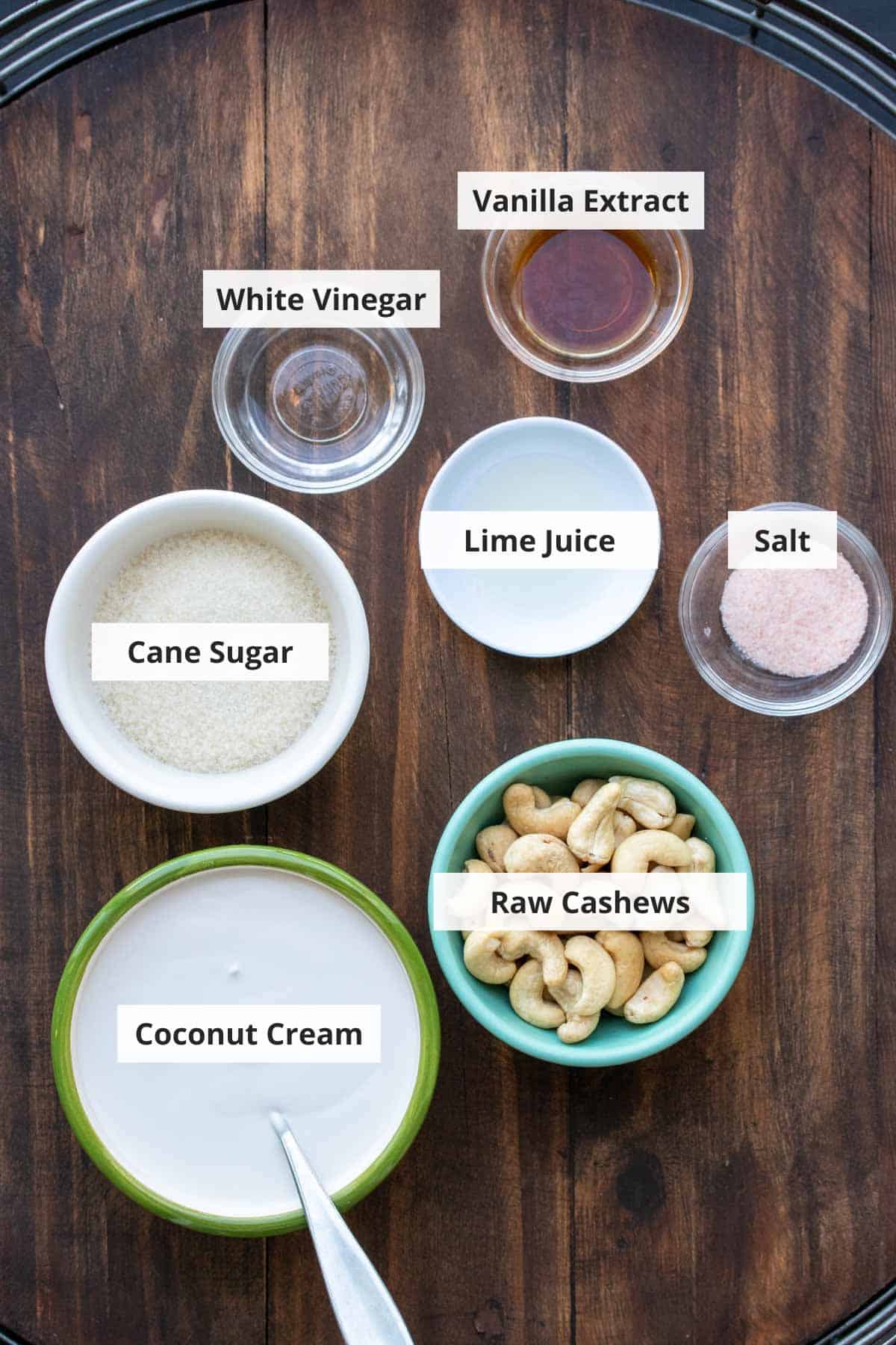 Ingredients for vegan cream cheese frosting recipe on a wood background.