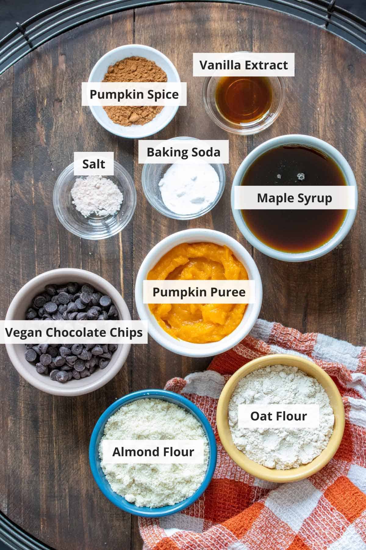 Ingredients for vegan pumpkin chocolate chip cookies on a wood background.