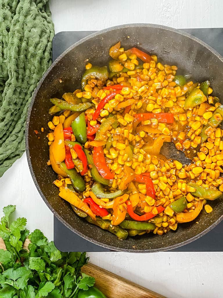 corn spices and veggies sauteeing in a pan