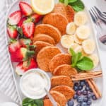 thick and fluffy mini pancakes - silver dollar pancakes recipe on a white plate with fresh fruit
