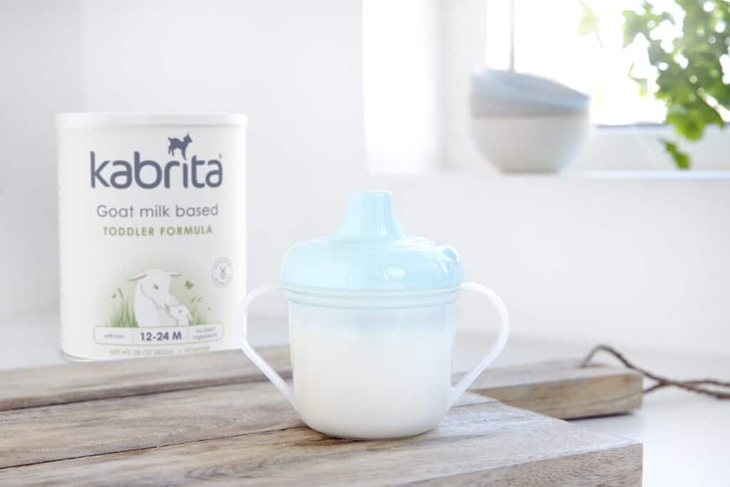 Kabrita goat milk formula canister and milk in sippy cup.