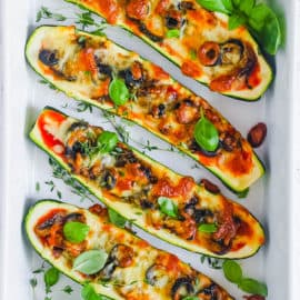easy healthy vegetarian low carb zucchini pizza boats recipe on a white tray