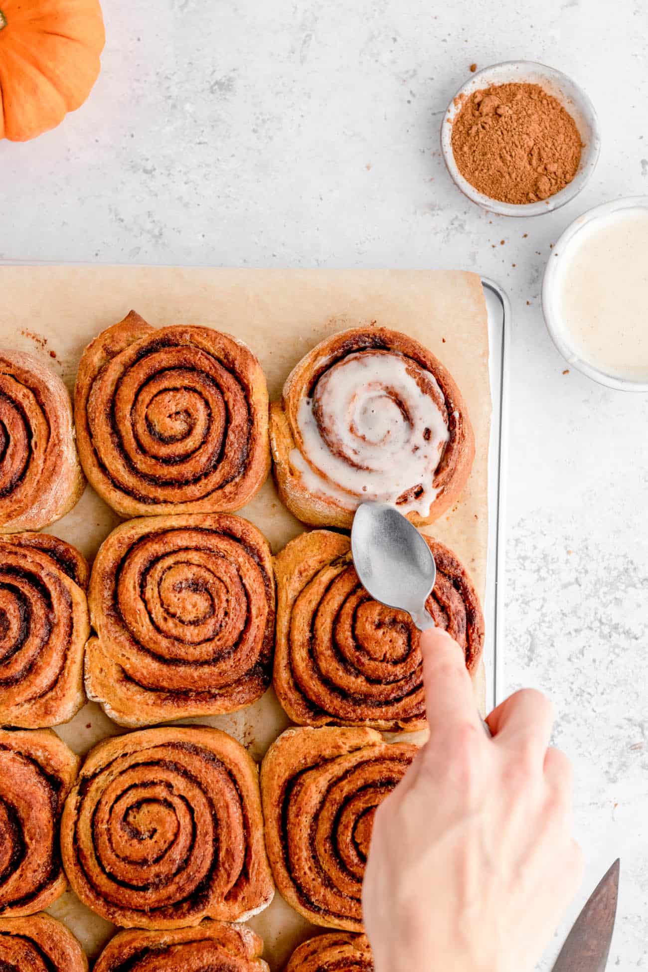 Icing added to the tops of the rolls with a spoon.