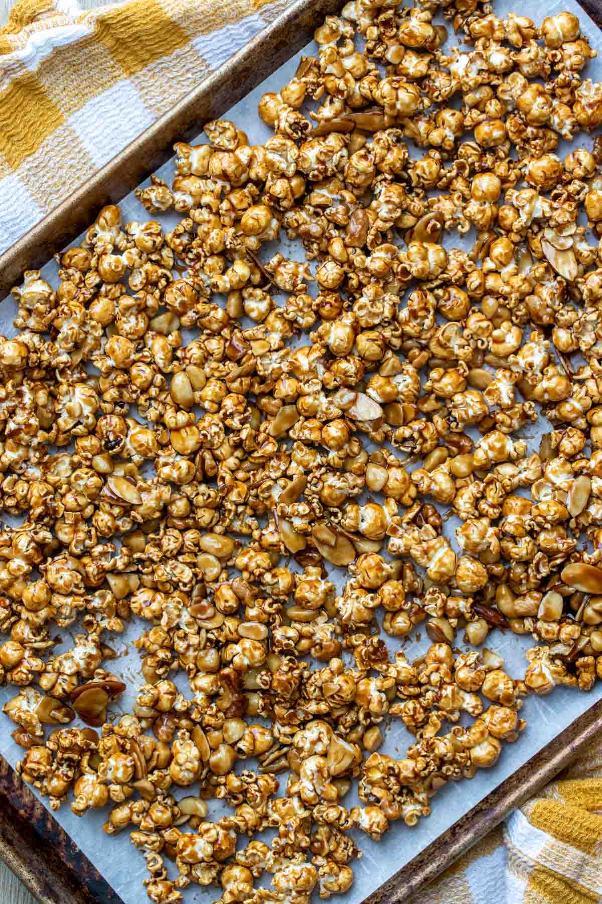 vegan caramel popcorn spread out onto a baking sheet