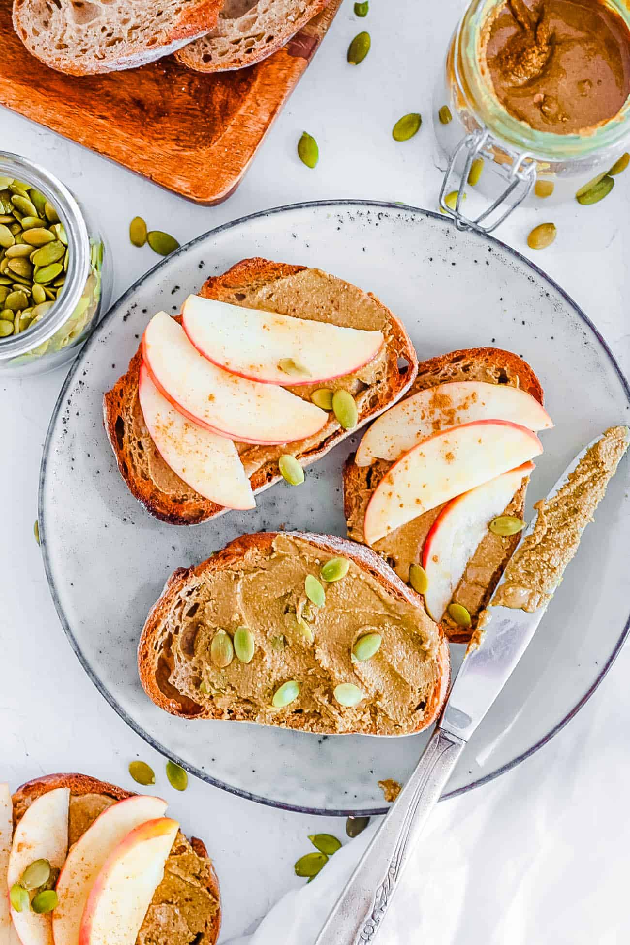 easy healthy vegan homemade pumpkin seed butter recipe spread on toast with fresh apple slices on top