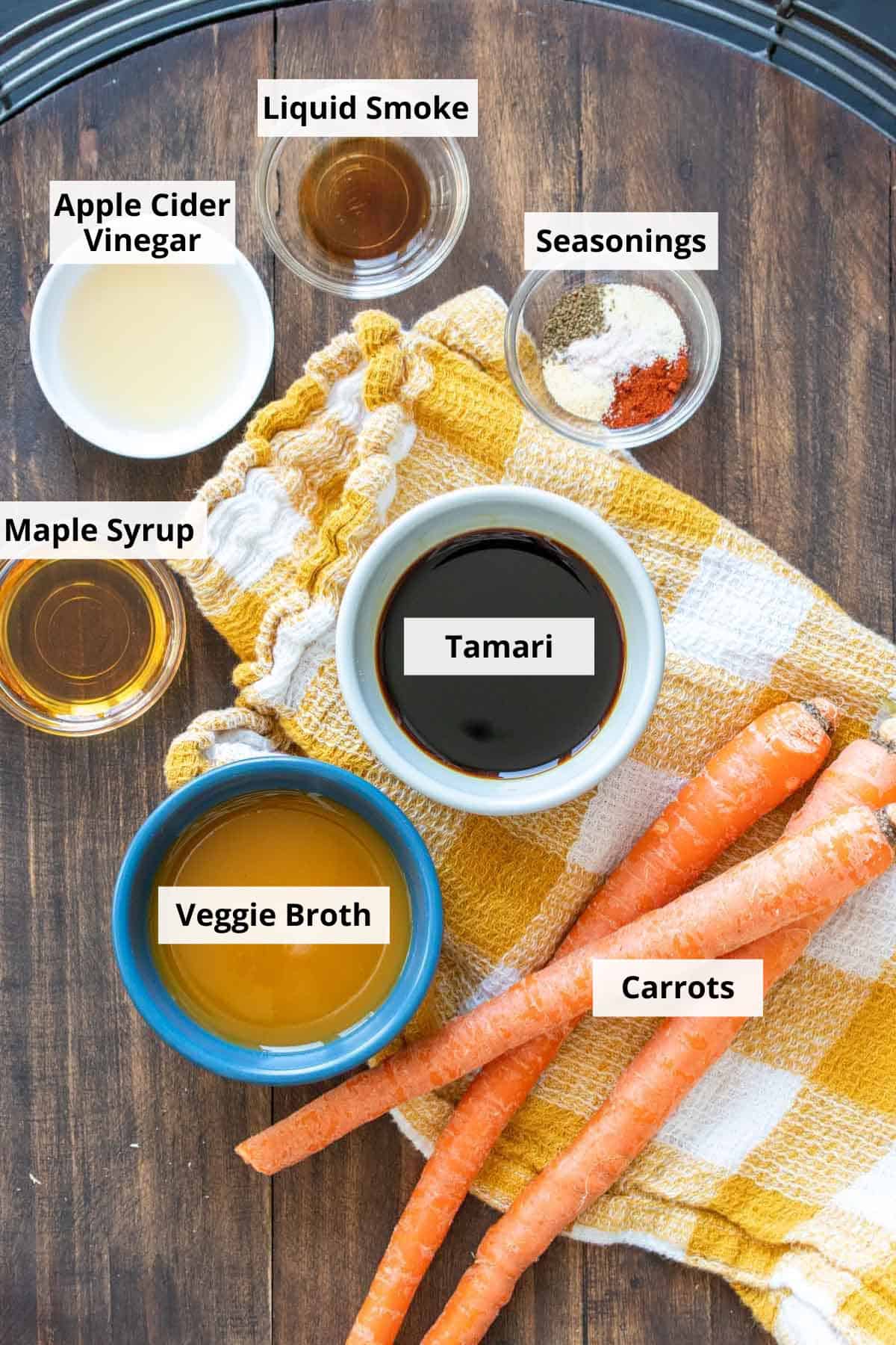 A wooden tray with 3 carrots and ingredients to make a marinade for them