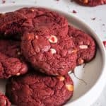 Red velvet cookies with white chocolate chips on plate.