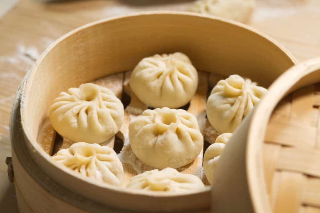 foods that start with x - Closeup of raw buns in bamboo steamer, handmade baozi, homemade Chinese food