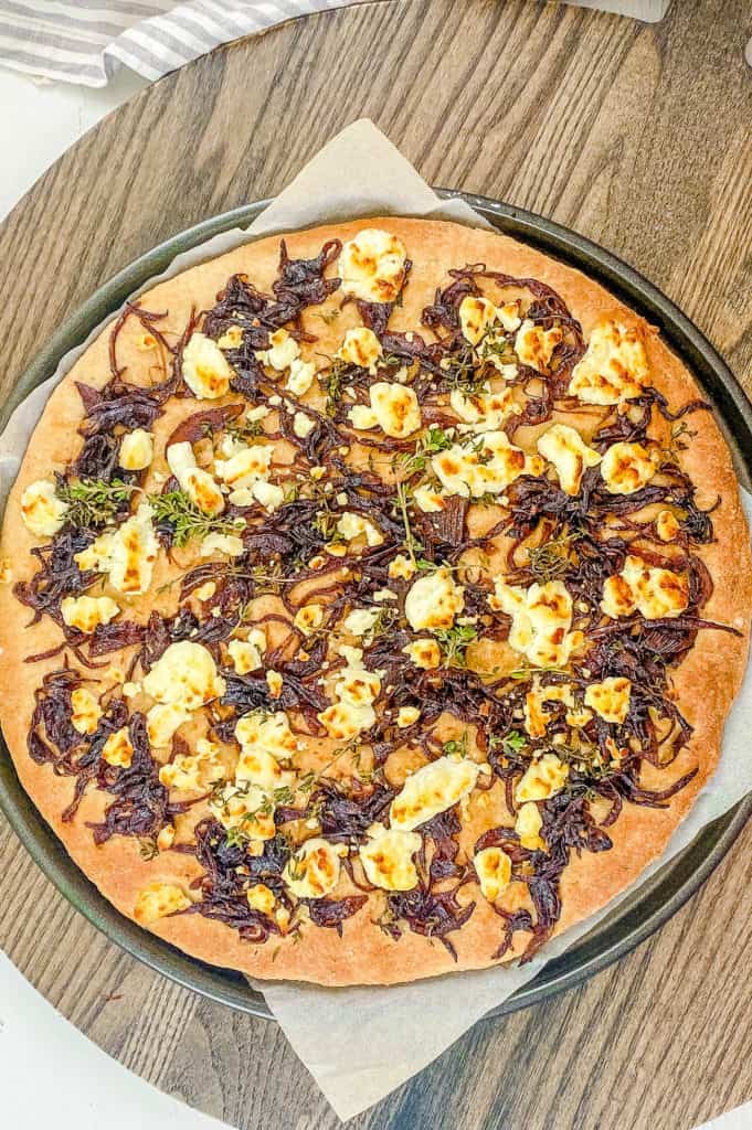baked homemade goat cheese pizza recipe with caramelized onions and arugula