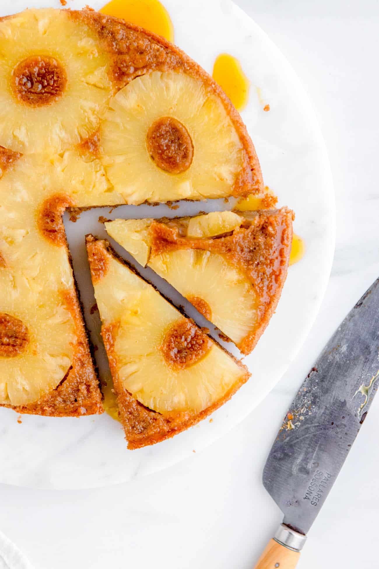 slices of easy gluten free eggless vegan pineapple upside down cake recipe on a cake platter