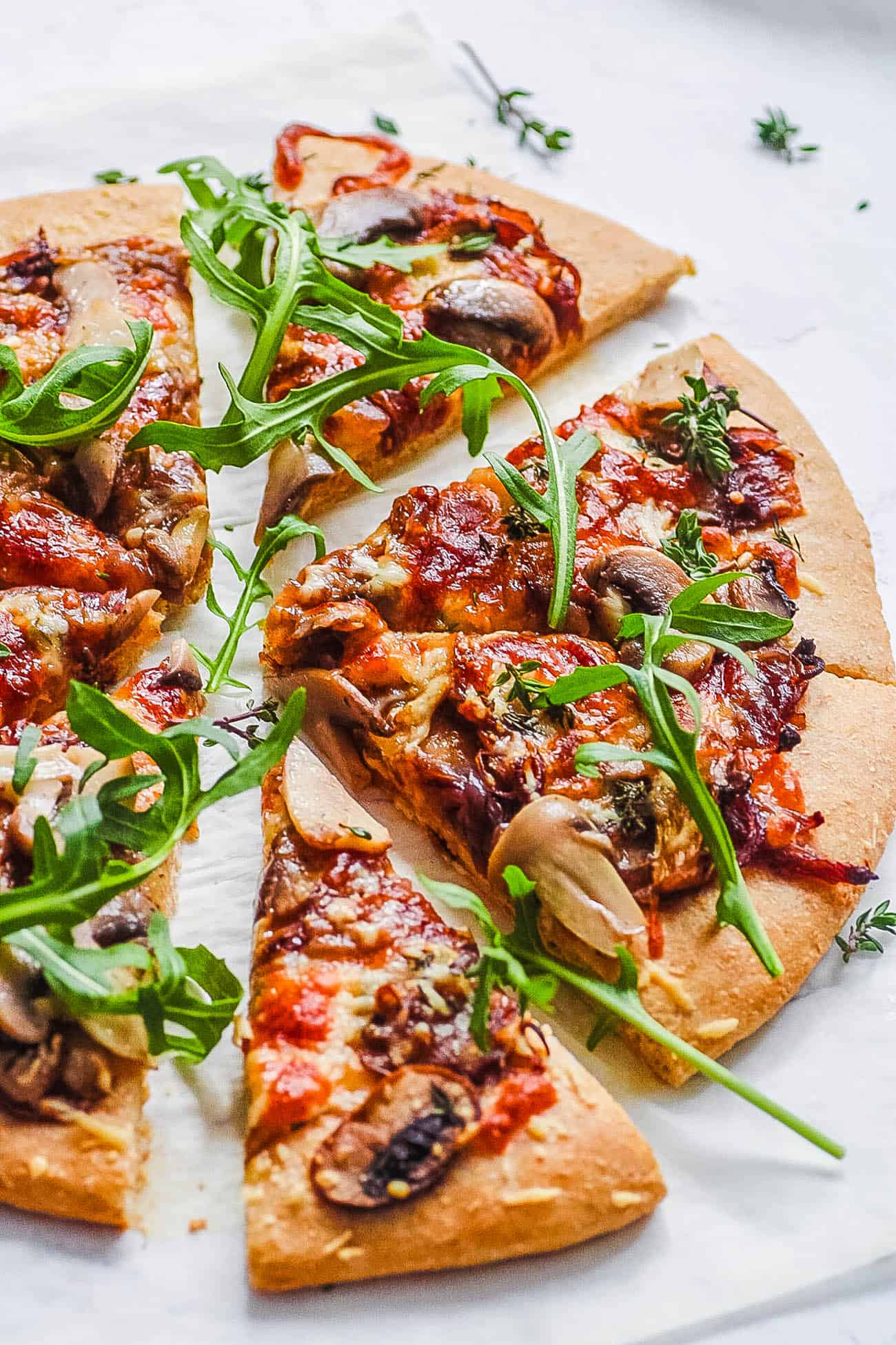 easy rustic pizza recipe with mushrooms and garlic cut into slices on parchment paper