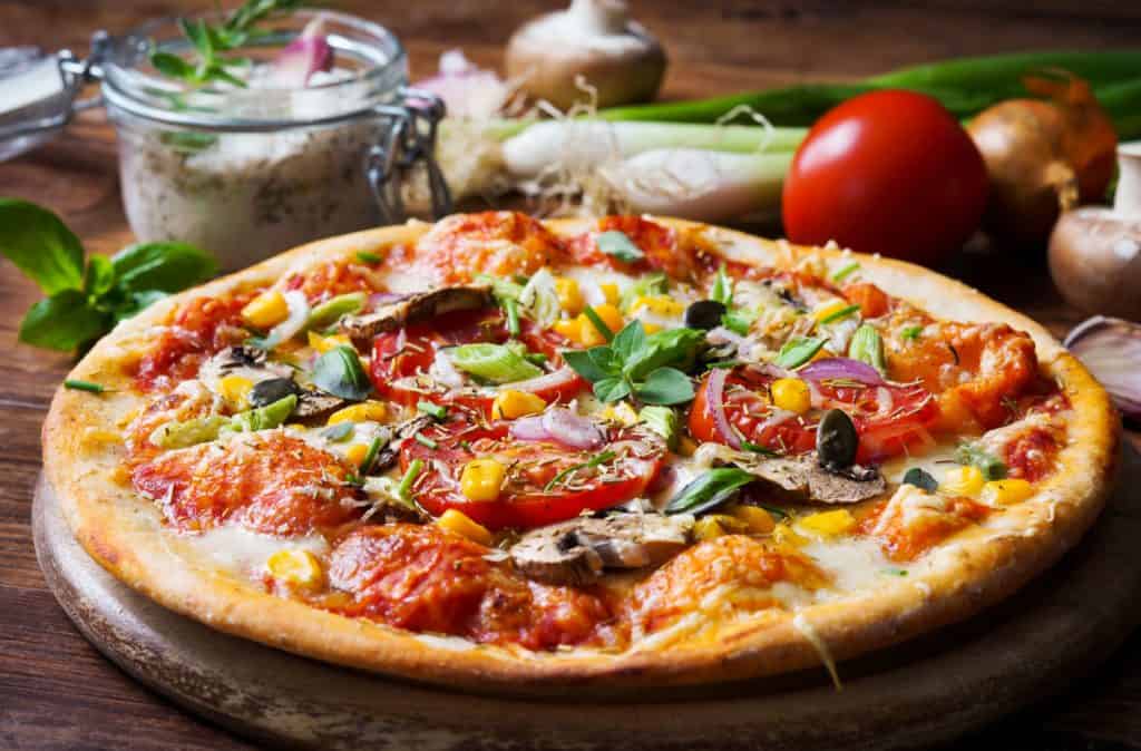 low calorie pizza base baked in the oven -- Homemade pizza with vegetables and fresh herbs