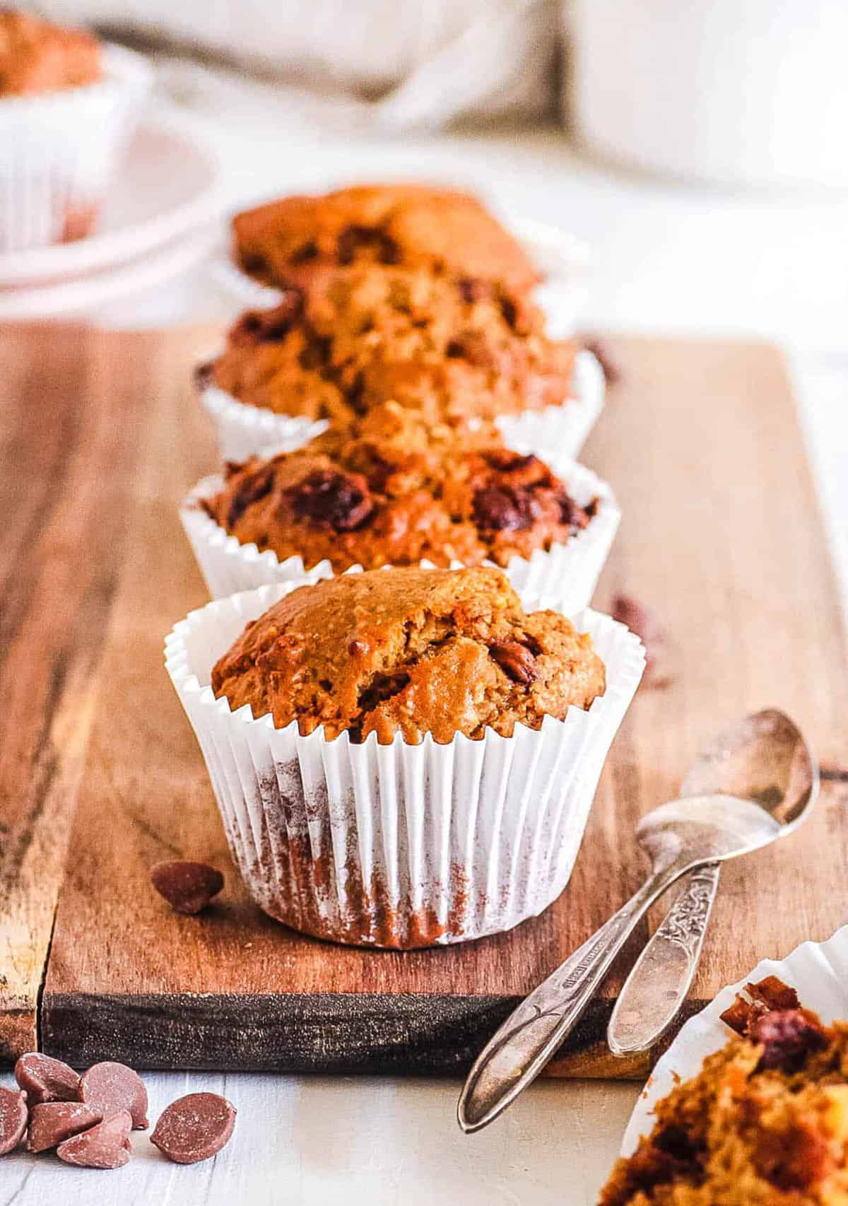 Easy peanut butter muffins with chocolate chips on a wooden cutting board.