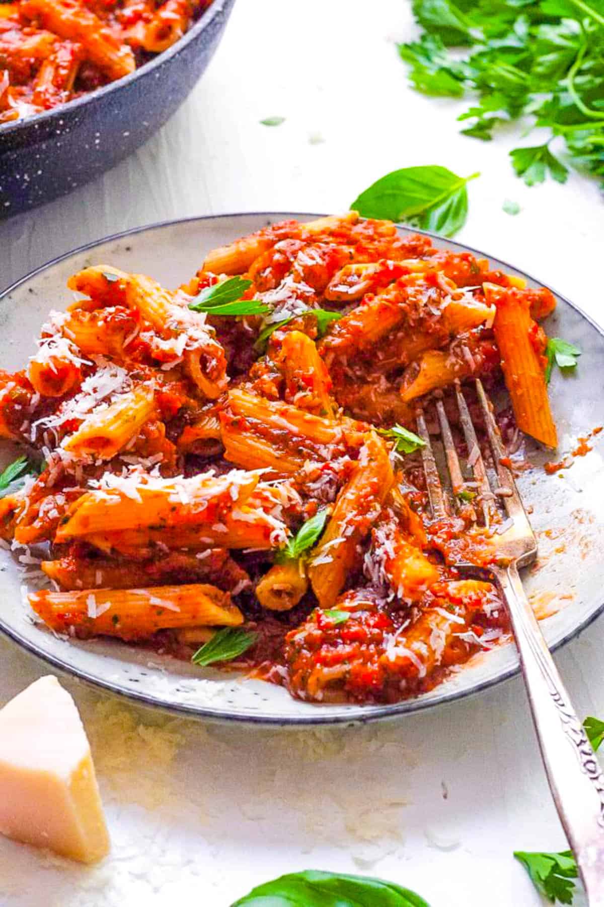 Red lentil pasta served on a white plate with superfood marinara sauce.