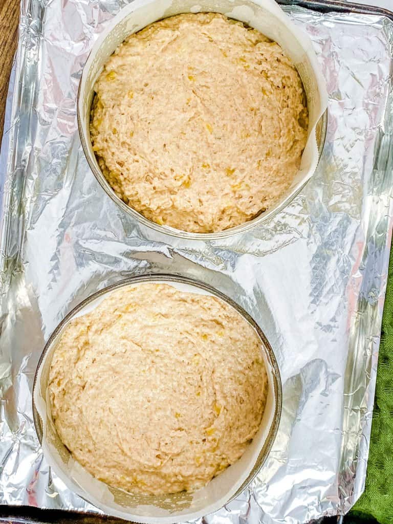 The cake batter divided evenly between the cake pans before baking.