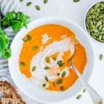 easy, creamy, ginger carrot coconut soup recipe (vegan, gluten free and dairy free) in a white bowl