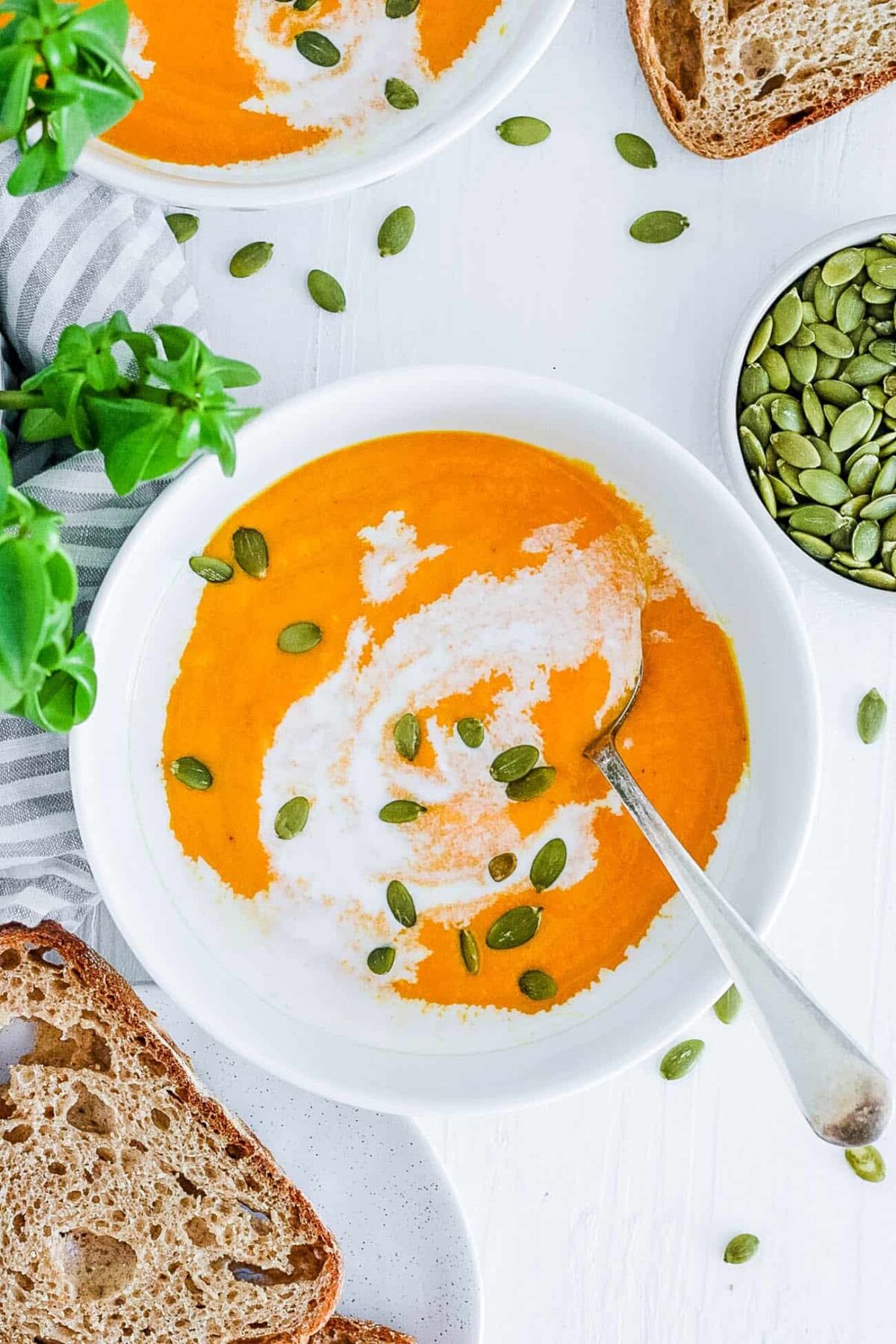 easy, creamy, ginger carrot coconut soup recipe (vegan, gluten free and dairy free) in a white bowl
