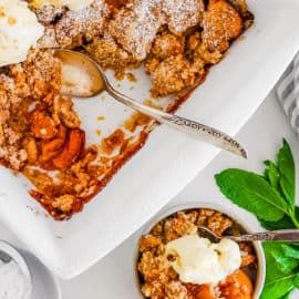 easy healthy dairy free gluten free vegan peach cobbler recipe in a white bowl with ice cream