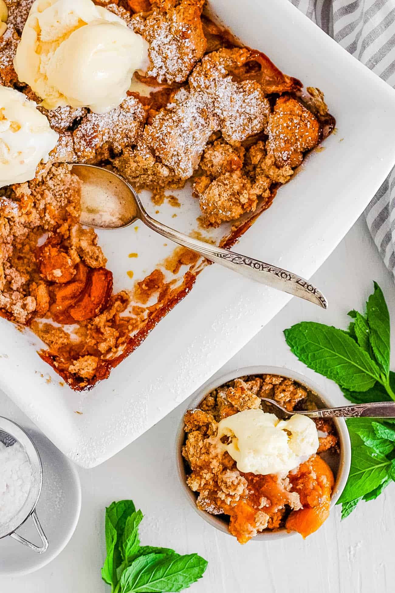 easy healthy dairy free gluten free vegan peach cobbler recipe in a white bowl with ice cream